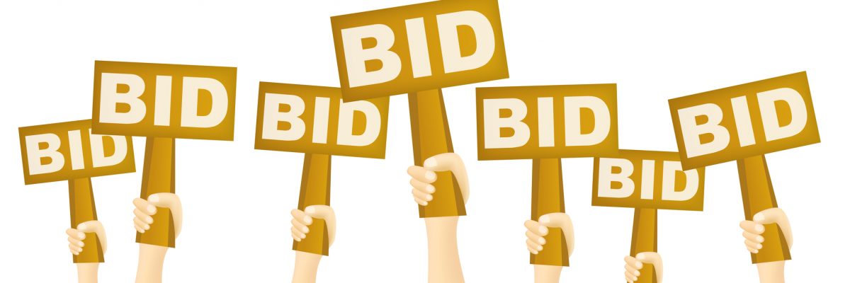 Hands holding BID sign to buy from auction.